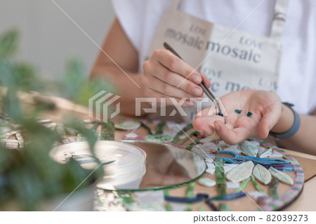 Hands of master working on new modern colorful mosaic. Close-up Hands of master working on new modern colorful mosaic. Close-up 82039273