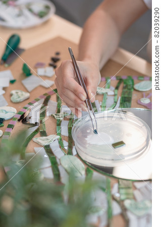 Hands of master working on new modern colorful mosaic. Close-up 82039290