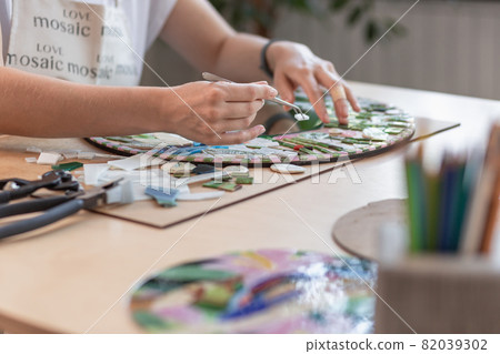 Hands of master working on new modern colorful mosaic. Close-up Hands of master working on new modern colorful mosaic. Close-up 82039302