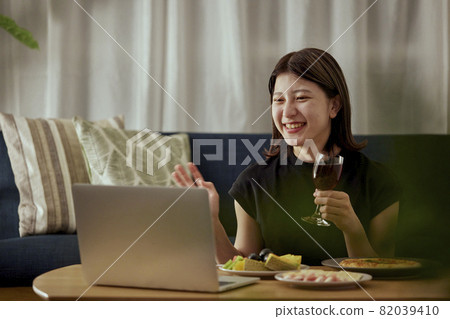 一個年輕的日本女人獨自在家喝酒 82039410