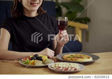 一個年輕的日本女人獨自在家喝酒 82039413
