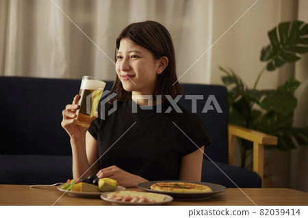 一個年輕的日本女人獨自在家喝酒 82039414