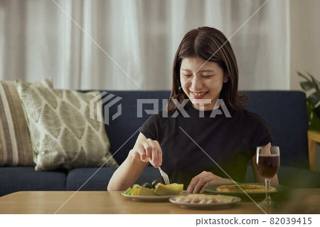 一個年輕的日本女人獨自在家喝酒 82039415