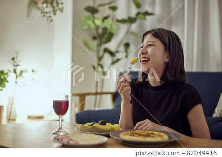 A young Japanese woman enjoying alcohol alone at home 82039416