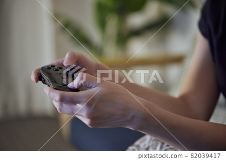 年輕的日本女人在客廳玩遊戲 82039417
