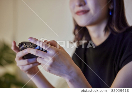 年輕的日本女人在客廳玩遊戲 82039418