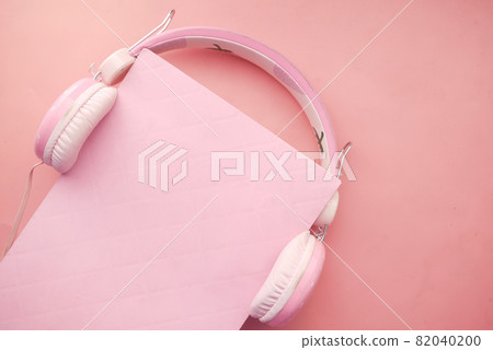 Audio book concept. Headphones and book on pink background Audio book concept. Headphones and book on pink background 82040200