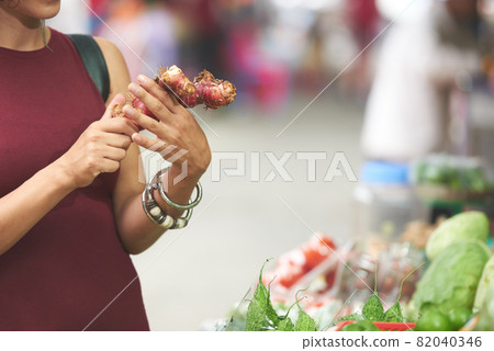 Woman Buying Ginger Roots Woman Buying Ginger Roots 82040346