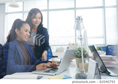 Friendly Businesswoman Helping New Coworker Friendly Businesswoman Helping New Coworker 82040793