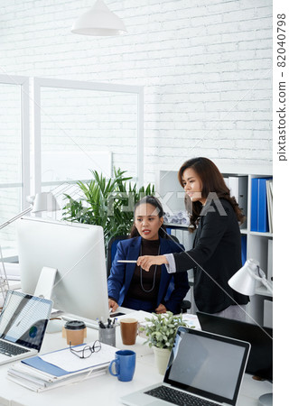 Female Coworkers Discussing Data on Screen Female Coworkers Discussing Data on Screen 82040798