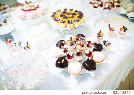 Delicious sweets on wedding candy buffet with desserts, cupcakes Delicious sweets on wedding candy buffet with desserts, cupcakes 82043275