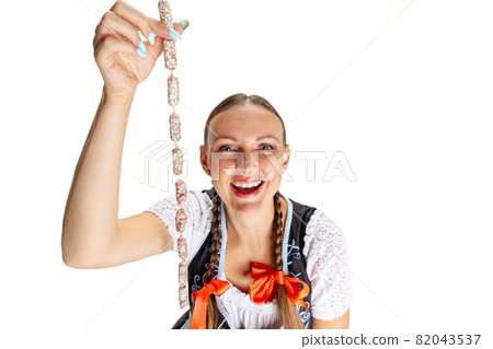 High angle view of smiling Oktoberfest woman, waitress wearing a traditional Bavarian or german dirndl isolated on white studio background. 82043537