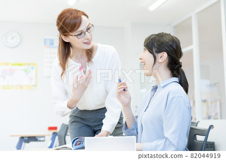 A Western teacher wearing glasses in an English conversation class and a young woman Photographing cooperation: Japanese language school attached to Chuo College of Technology 82044919