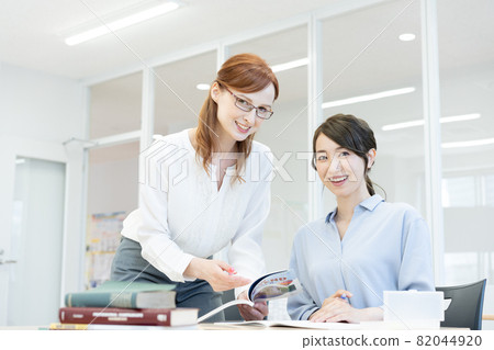 A Western teacher wearing glasses in an English conversation class and a young woman Photographing cooperation: Japanese language school attached to Chuo College of Technology A Western teacher wearing glasses in an English conversation class and a young woman Photographing cooperation: Japanese language school attached to Chuo College of Technology 82044920