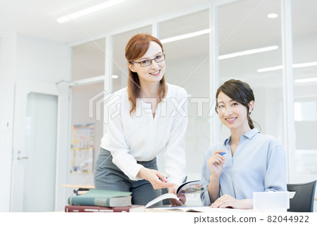 A Western teacher wearing glasses in an English conversation class and a young woman Photographing cooperation: Japanese language school attached to Chuo College of Technology 82044922
