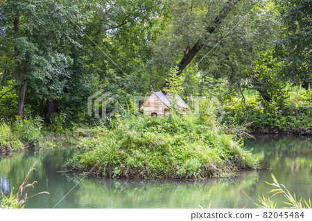 Small wooden house for waterfowl on the surface of the pond 82045484