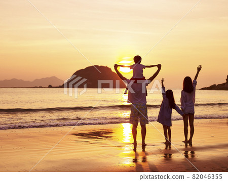 asian family standing on beach watching and enjoying the sunrise or sunset asian family standing on beach watching and enjoying the sunrise or sunset 82046355