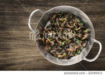 Shiitake mushrooms sauteed with garlic and herbs in metal pan Shiitake mushrooms sauteed with garlic and herbs in metal pan 82046411