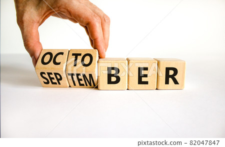 Symbol for the change from September to october. Businessman turns wooden cubes and changes the word 'September' to 'October'. Beautiful white background, copy space. Happy October concept. Symbol for the change from September to october. Businessman turns wooden cubes and changes the word 'September' to 'October'. Beautiful white background, copy space. Happy October concept. 82047847