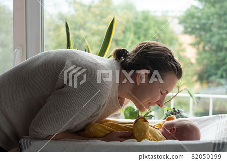 Caucasian mother changing baby girl clean cloth Caucasian mother changing baby girl clean cloth 82050199