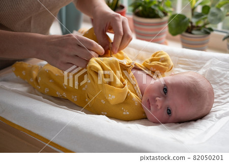 Caucasian mother changing baby girl clean cloth Caucasian mother changing baby girl clean cloth 82050201