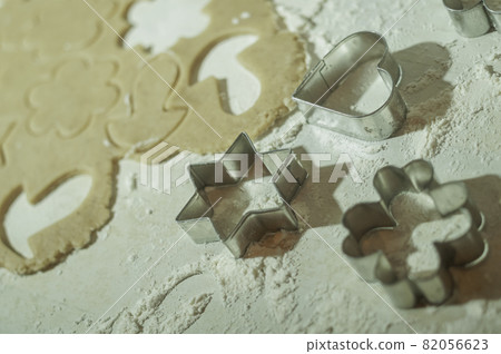 Cookie molds, with rolled dough and flour on the table. Cookie molds, with rolled dough and flour on the table. 82056623