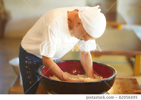Men who add water to buckwheat flour and mix Men who add water to buckwheat flour and mix 82056895