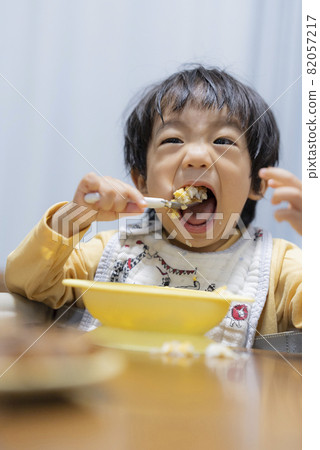 一個一歲半的男孩自己用勺子吃飯 82057217