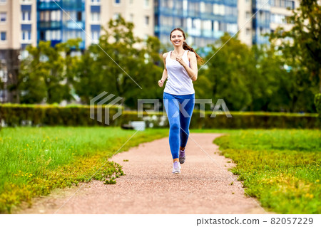 Happy woman runs in park for being healthy. Happy woman runs in park for being healthy. 82057229