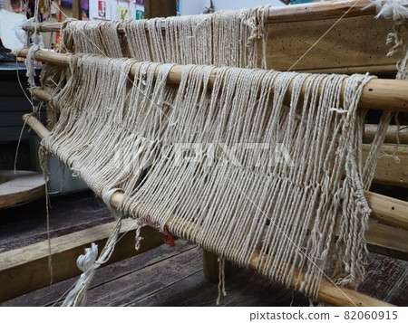 Loom and threads. Antique equipment for the production of carpets, clothing and woven household items. Threads and yarns are pulled over bushings and slats. Trsic, Loznica, Serbia. Ethno tourism Loom and threads. Antique equipment for the production of carpets, clothing and woven household items. Threads and yarns are pulled over bushings and slats. Trsic, Loznica, Serbia. Ethno tourism 82060915