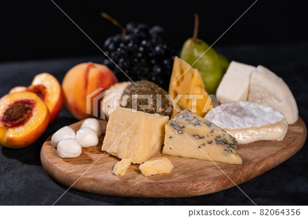 Various kinds of cheese with walnuts and grapes 82064356