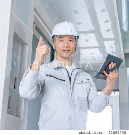 在建築工地廣場邊看平板電腦邊檢查工地的工地主管 82065366