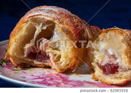 Croissant with strawberry filling on a dark background 82065938