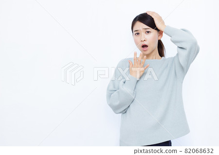 A woman in her thirties holding her head A woman in her thirties holding her head 82068632