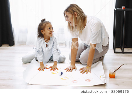 Woman and little girl painting hand and making prints 82069176