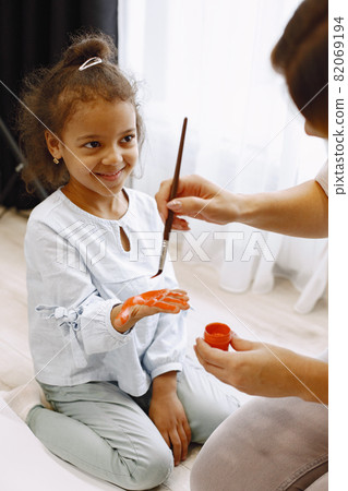 Woman and little girl painting hand and making prints 82069194
