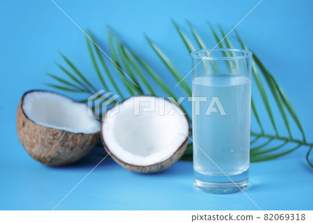 slice of fresh coconut and glass of coconut water on table  82069318