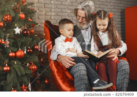Smiling grandfather and grandchild with gift boxes sitting at home 82070409