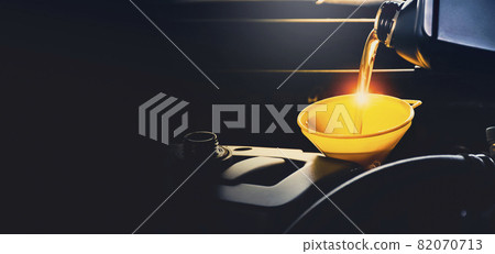 Mechanic man pouring lubricant oil to car engine in the repair garage with copy space Mechanic man pouring lubricant oil to car engine in the repair garage with copy space 82070713