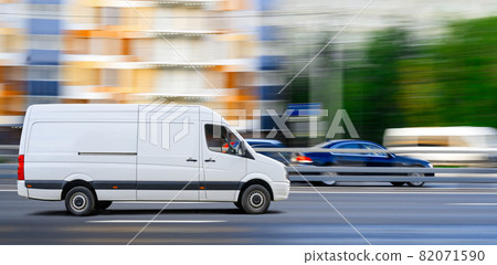 White van drives on city traffic on cityscape background. White van drives on city traffic on cityscape background. 82071590