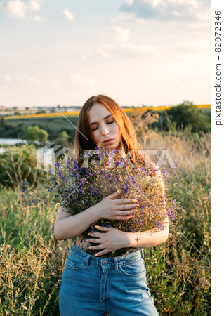 Healing Power of Nature, Benefits Of Ecotherapy, Nature Impact Wellbeing. Happy young girl holding wildflowers bouquet, relaxing and enjoying life 82072346