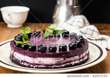 Homemade blueberry cheesecake garnished with preserved blueberry and mint leaf. Homemade blueberry cheesecake garnished with preserved blueberry and mint leaf. 82073133