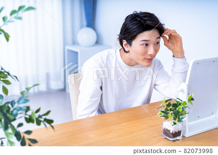 一個男人在鏡子裡檢查他的皮膚 一個男人在鏡子裡檢查他的皮膚 82073998