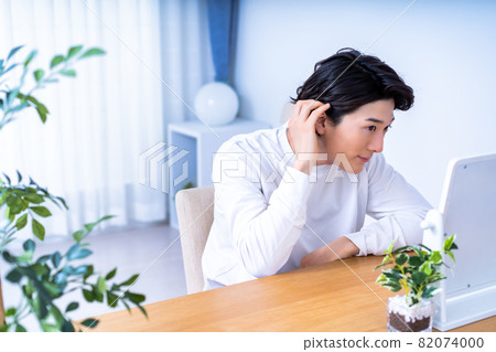 一個男人在鏡子裡檢查他的皮膚 82074000