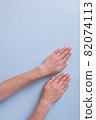 Stylish trendy female manicure. Beautiful young woman's hands on blue background. 82074113