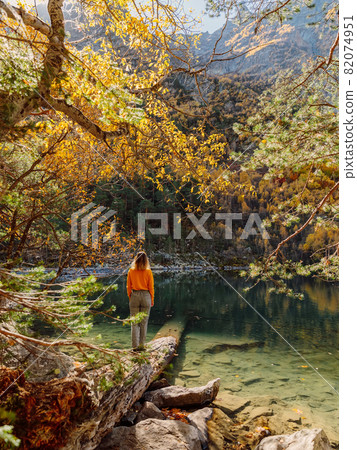 Traveller at crystal mountain lake in the autumnal landscape. Traveller at crystal mountain lake in the autumnal landscape. 82074951