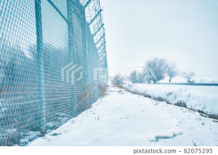 Fence with barbed wire on the border in winter time. Fence with barbed wire on the border in winter time. 82075295