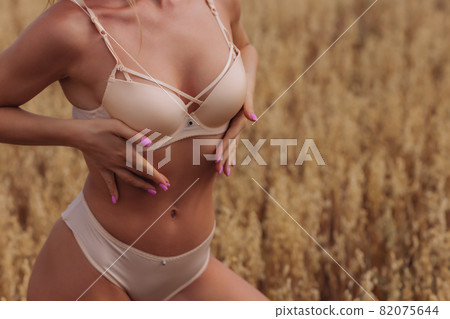 A young woman in underwear in a field of wheat. A young woman in underwear in a field of wheat. 82075644