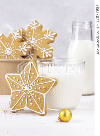 Delicious fresh milk on a white wooden background. Bottle of milk. Gingerbread Christmas. Delicious fresh milk on a white wooden background. Bottle of milk. Gingerbread Christmas. 82077987