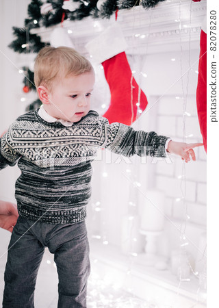 Christmas portrait of a young boy cozy atmosphere around the fireplace and Christmas tree 82078280